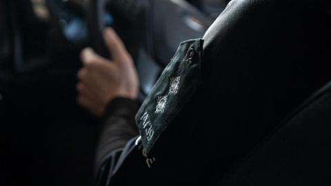 Arm of a police officer wearing uniform and badge 