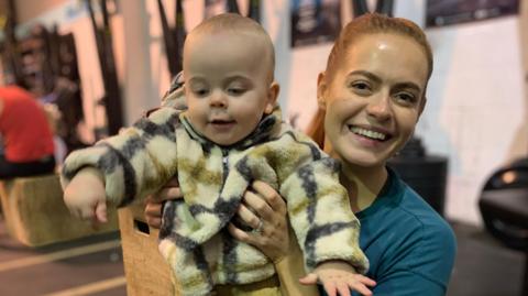 West End star Sophie Evans lifting her son Jack as part of the exercise in this gym class