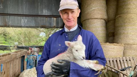 Farmer Tobin Bird holding a lamb