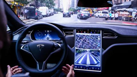A driver rides hands-free in a Tesla's Model S vehicle equipped with Autopilot hardware and software in New York.