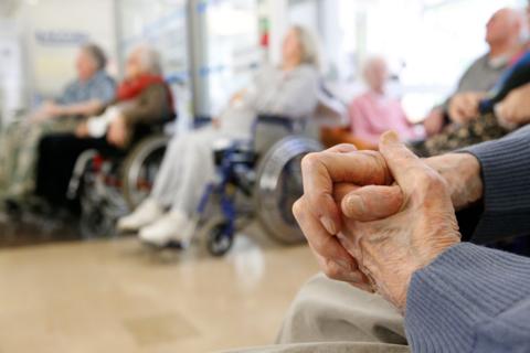 Elderly people in wheelchairs sitting in a sunny room