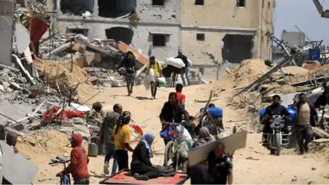 People in rubble in Khan Younis, Gaza, 8 April