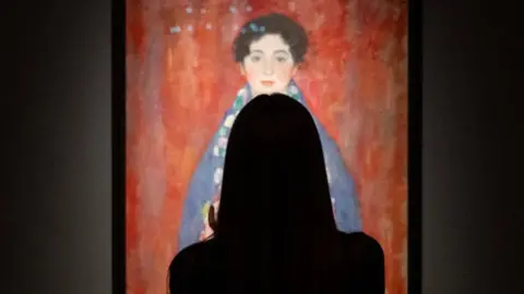 A visitor is looking at the rediscovered painting of a young female ''Portrait of Miss Lieser'' by the Austrian painter Gustav Klimt on a display at the im Kinsky auction house in Vienna,