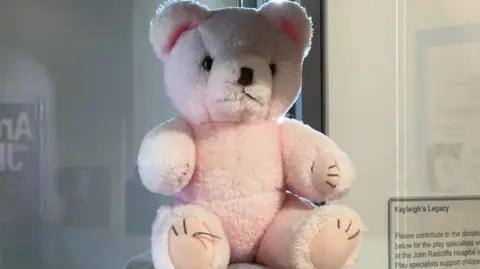 Kayleigh the teddy bear in a glass case