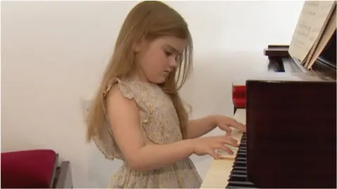 Young girl plays piano