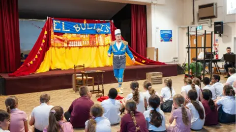 Professional opera singer performing in a school hall to an audience of children