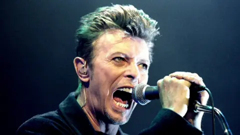 David Bowie sings into a microphone