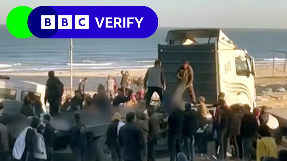 Image of people pulling bodies onto a lorry in the aftermath of the incident