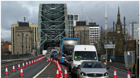 Traffic crossing the Tyne Bridge with cones separately the traffic into one lane in each direction