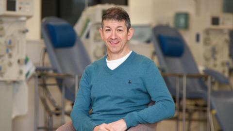 A man sitting in front of donation machines