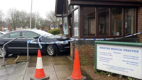 A dark blue car in the front of a Lincoln GP surgery