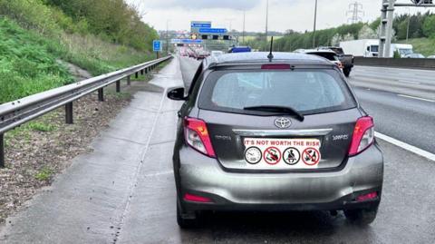 A grey Yaris car stopped on the M1 motorway