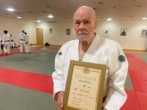 Michael Leigh holding his ninth dan certificate