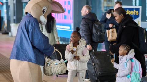 The Easter Bunny handing out chocolate eggs to Luton Dart Customers