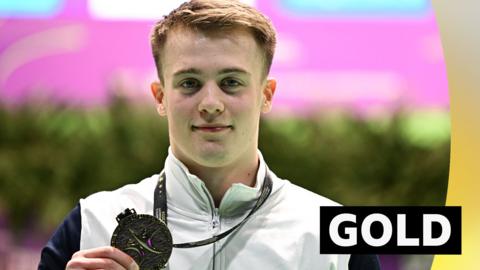 Luke Whitehouse holds up his gold medal at the Gymnastics European Championships