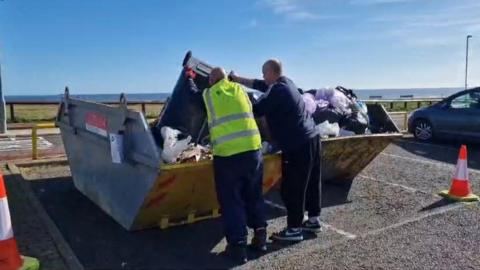 Bin being emptied into skip at Whitburn car park