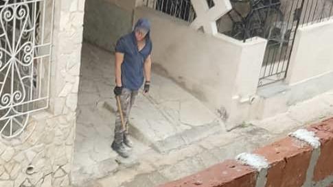 An armed man waits in the street outside Father Juan's house in Cuba