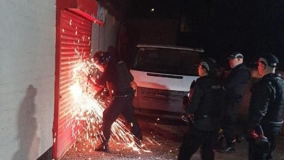 Police officers breaking into a garage