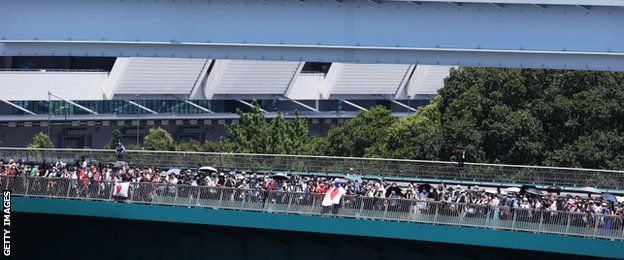 Fans watch BMX freestyle from a bridge