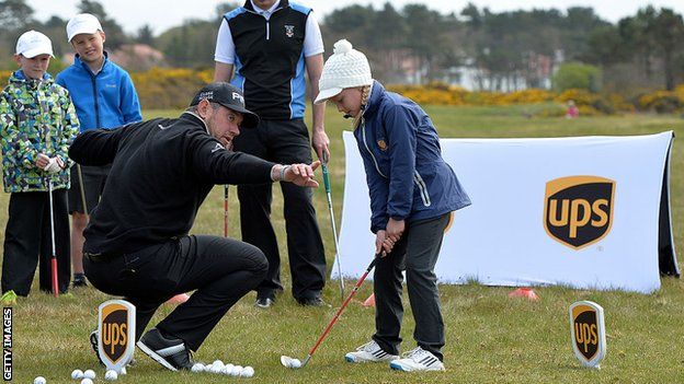 Lee Westwood teaches a young girl golf