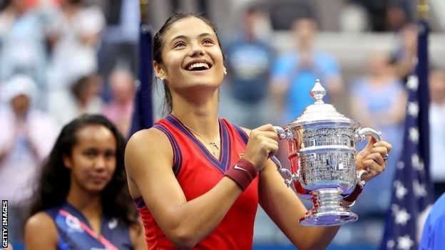 Emma Raducanu looks up while holding the US Open trophy