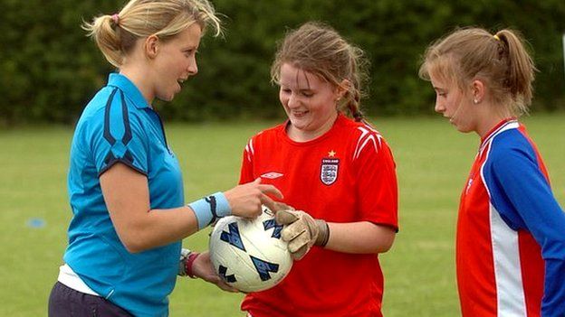 woman talking with two young footballers