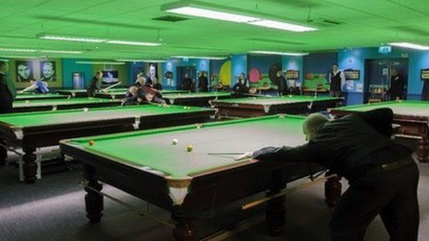 billiards hall with ten tables of players