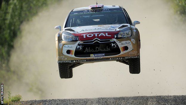 A rally car bouncing over a bump in the road.