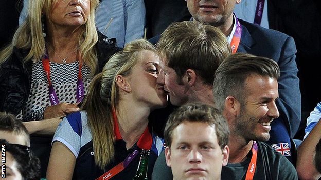 Laura Trott and Jason Kenny kiss behind David Beckham at the London 2012 beach volleyball