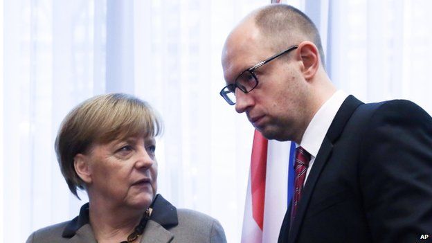 Ukrainian Prime Minister Arseniy Yatsenyuk, right, speaks with German Chancellor Angela Merkel after a signing ceremony at an EU summit in Brussels on Friday, March 21, 2014