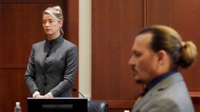 Johnny Depp looks on as Amber Heard takes the stand
