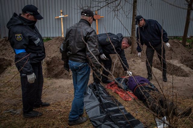 Полиция Бучи осматривает тело, обнаруженное в поле
