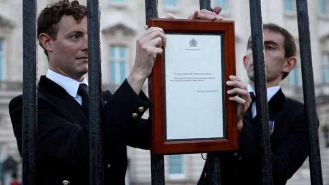 Buckingham Palace staff place the official notice of the Queen's death outside the palace