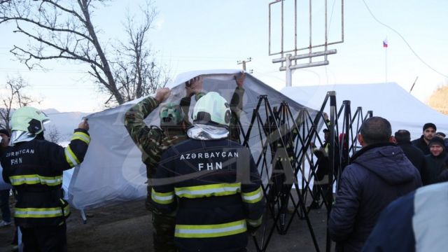 Работники МЧС помогают устанавливать палатку