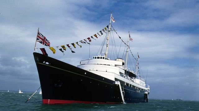 Корабль, украшенный флагами в море, рядом яхты