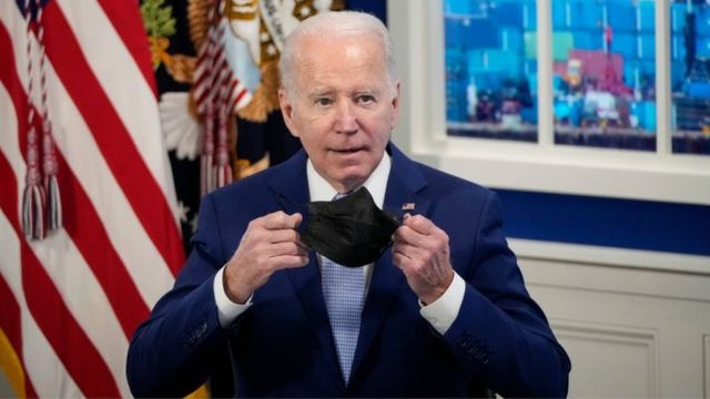 US President Joe Biden removes his mask before speaking during a meeting with his administration's Supply Chain Disruptions Task Force and private sector CEOs.