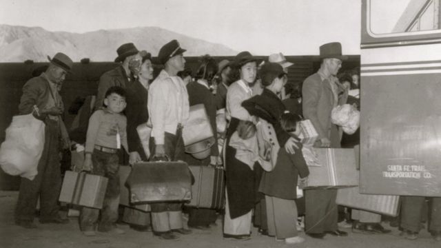 Американцы японского происхождения пересаживаются с поезда на автобус в Лоун-Пайн, Калифорния.