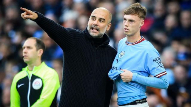 Pep Guardiola speaks with Cole Palmer