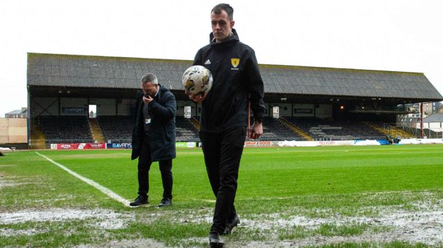 Referee Don Robertson calls the match off during a secondary pitch inspection ahead of a cinch Premiership match between Dundee and Rangers at the Scot Foam Stadium at Dens Park, on April 10, 2024, in Dundee, Scotland.