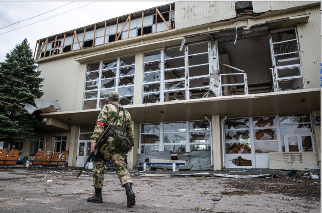 Военнослужащий Народной милиции ЛНР осматривает территорию разрушенной в результате обстрела железнодорожной станции.