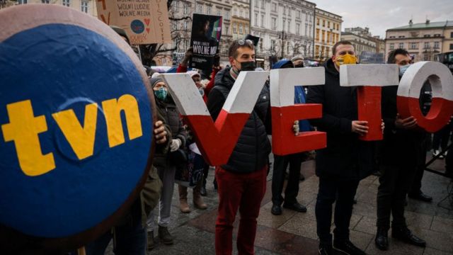Протесты против закона о СМИ в Варшаве. В руках людей плакаты с логотипом TVN и буквы слова VETO