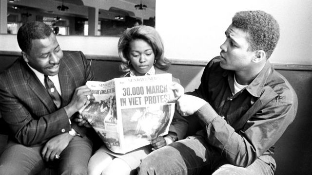 Мухаммед Али показывает на заголовок газеты о протесте против войны во Вьетнаме