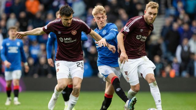angers' Ross McCausland against Hearts' Scott Fraser and Nathaniel Atkinson during a cinch Premiership match between Rangers and Heart of Midlothian at Ibrox Stadium