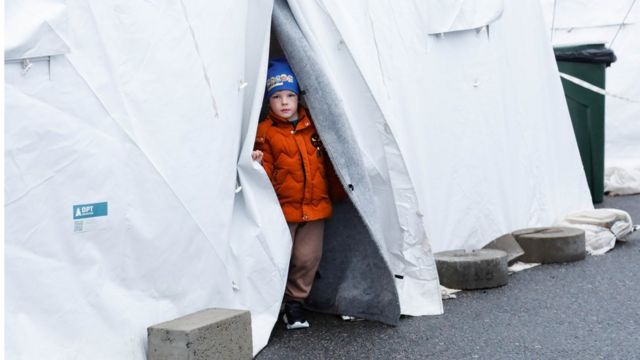 мальчик смотрит из палатки