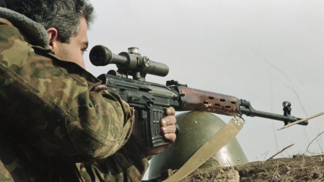 Военный в Карабахе смотрит в прицел автомата