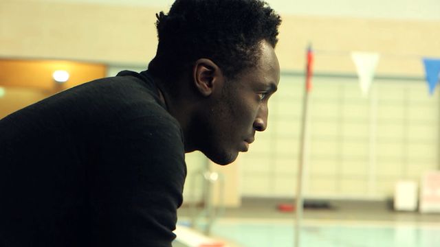 Andy Akinwolere by a swimming pool