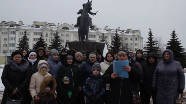 Группа людей на фоне памятника