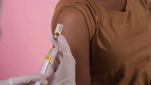 афро-американка получает дозу антиковидной вакцины