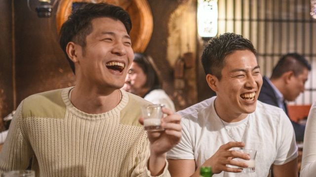Мужчины пьют саке в идзакая (баре) в Токио