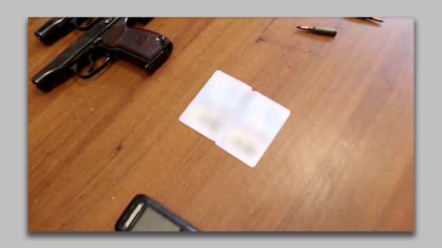 Размытые удостоверения личности двух марокканцев на столе рядом с двумя пистолетами и пулями.